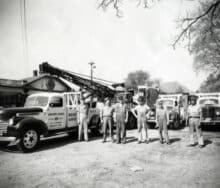 A group of men standing in front of a crane.
